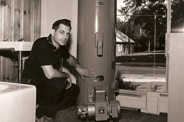 A Gottier technician installing a water heater in the 1960s